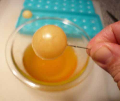 Coating the apple spheres in horseradish-infused white chocolate